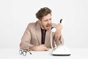 Angry client yelling down a phone following up a social media complaint