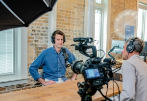 Pictture of a business owner being interviewed in front of a camera about video marketing