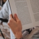 Picture of hands holding a book open as it's being read for social media marketing