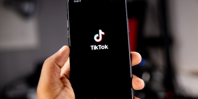 A mobile phone in someone's hand with the Tiktok loading screen