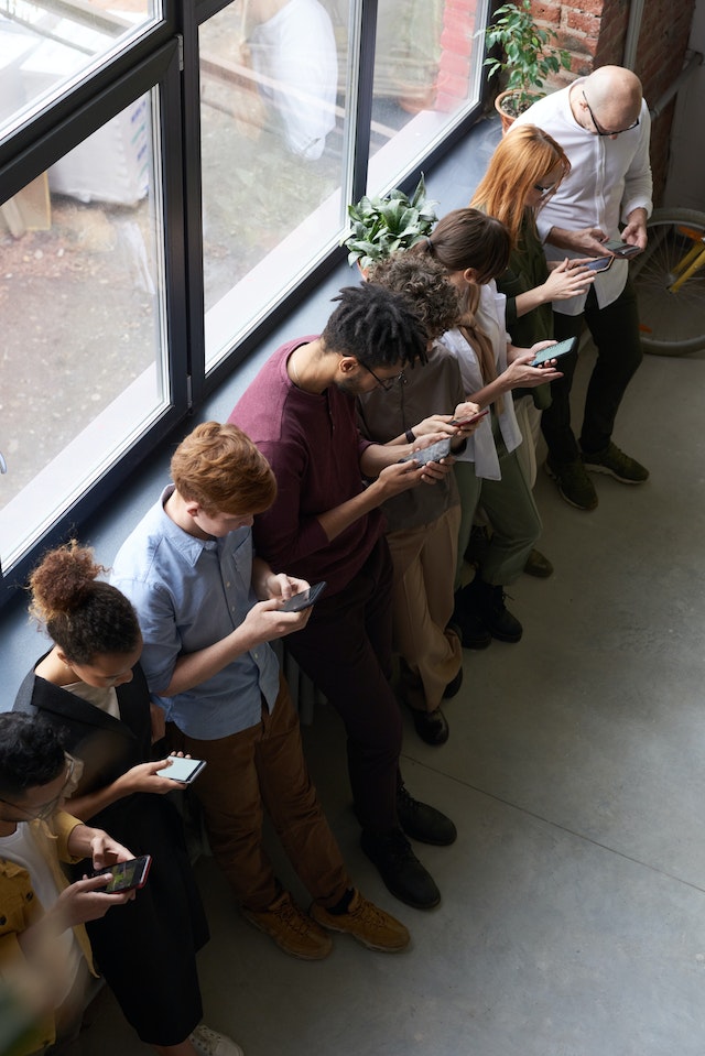 Social media users stood in a line on their mobile phones