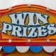Pictutre of a fairground sign that says 'win prizes'